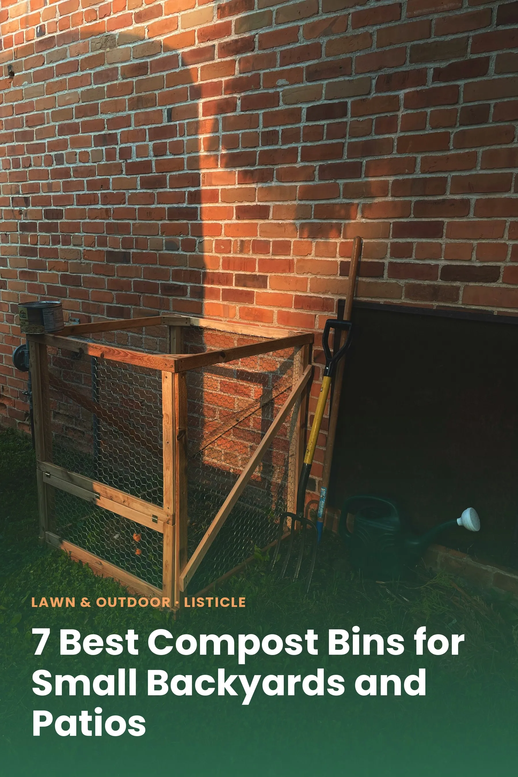 A DIY wire-and-wood compost bin against a brick wall in a backyard
