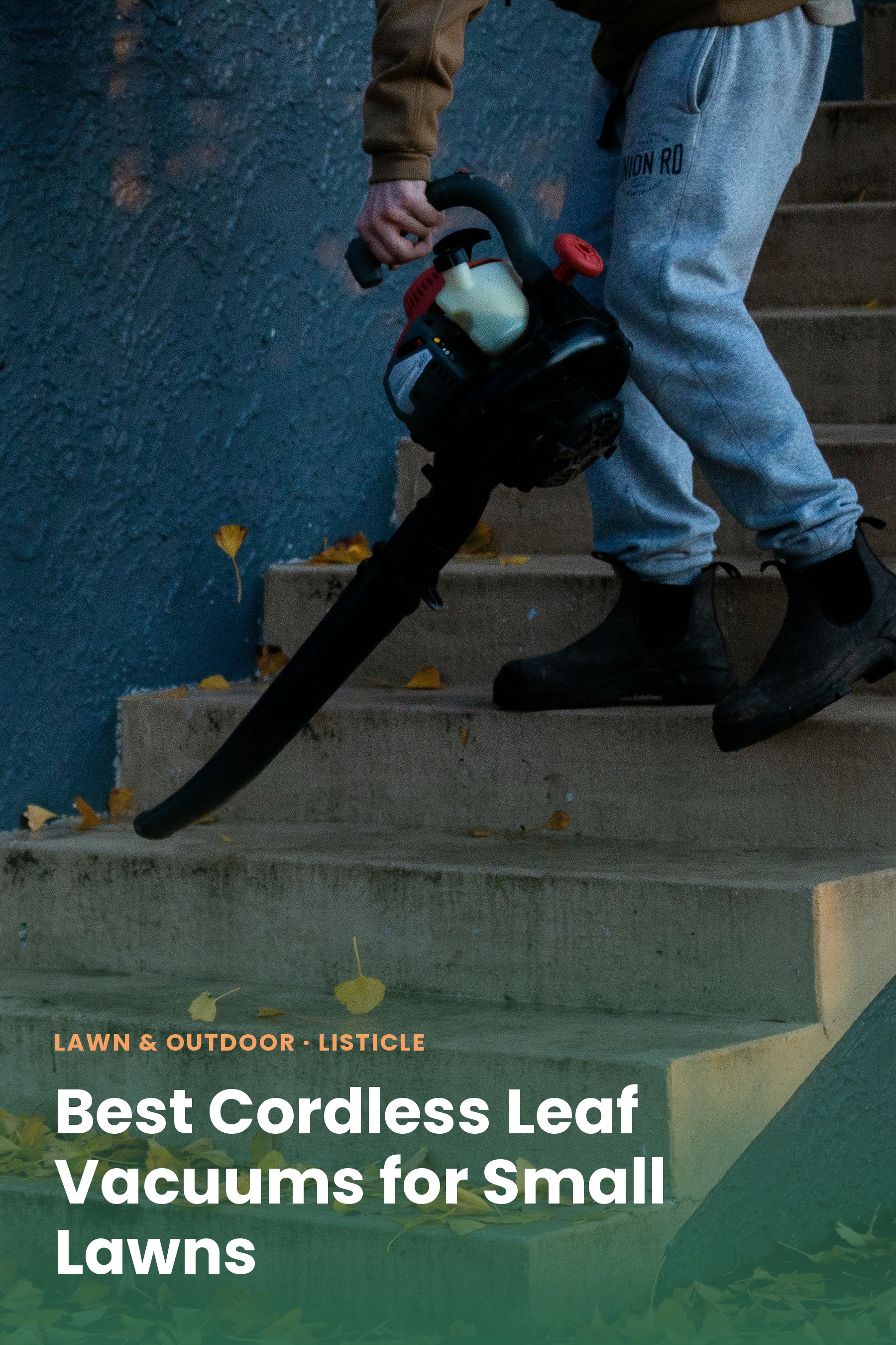 A person carrying a leaf blower down outdoor steps covered in fallen leaves