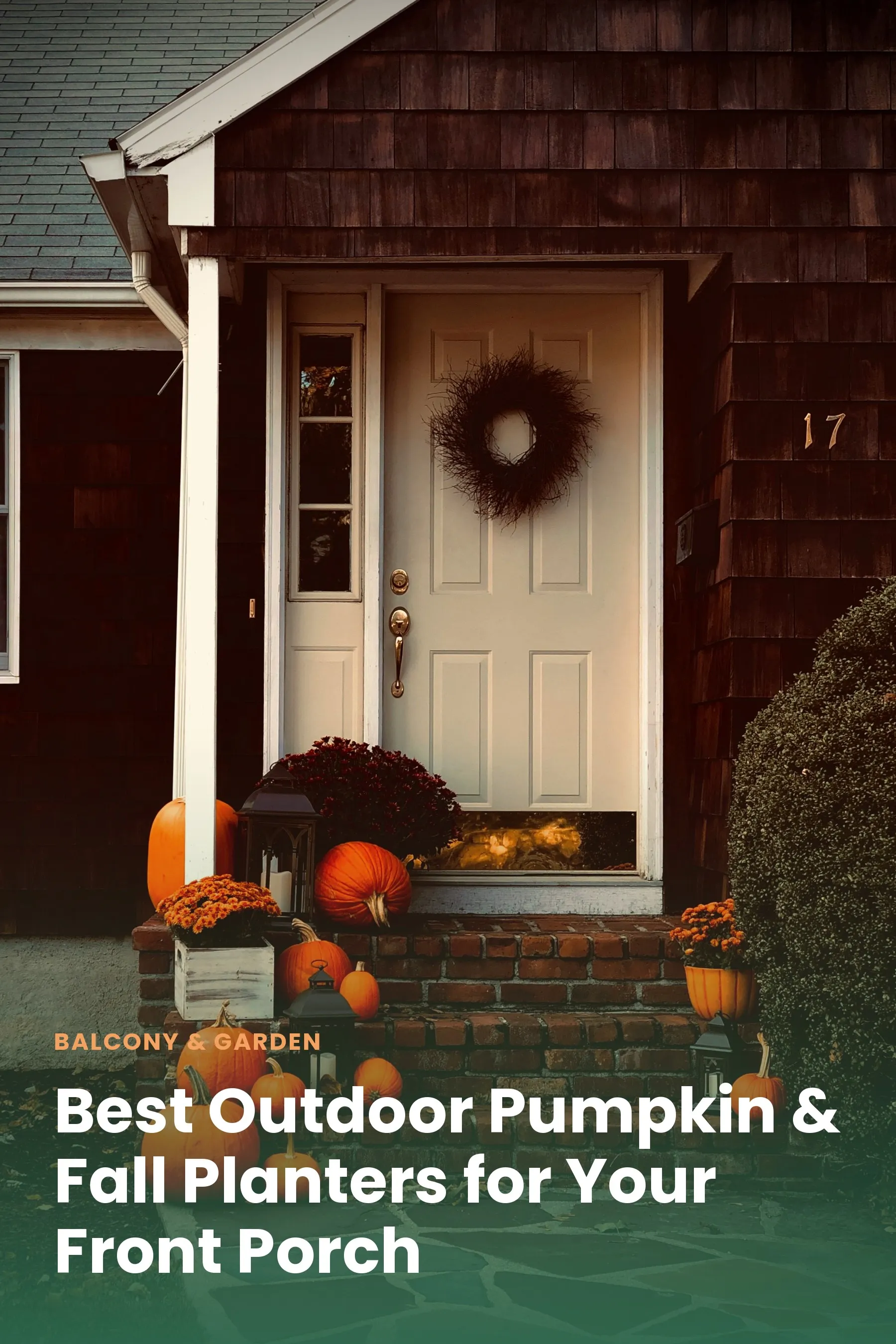 A front porch decorated with large fall planters filled with mums and pumpkins