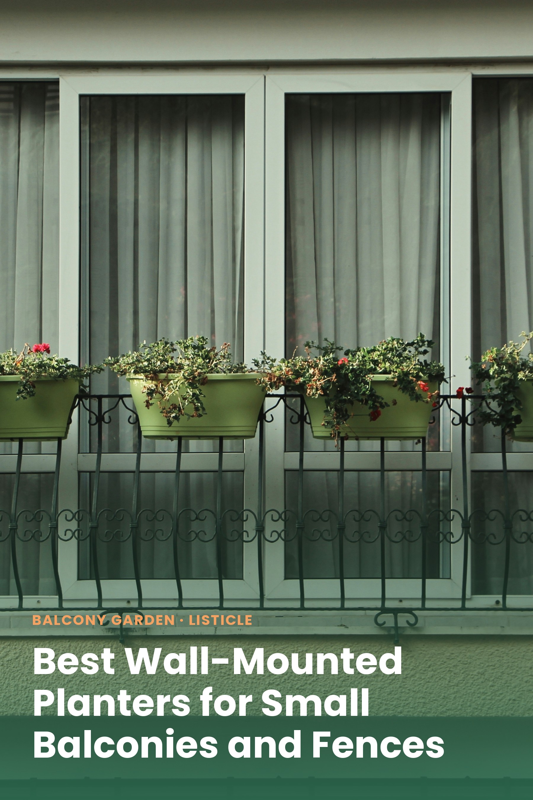 Green planters mounted on a balcony railing outside a window, filled with flowers