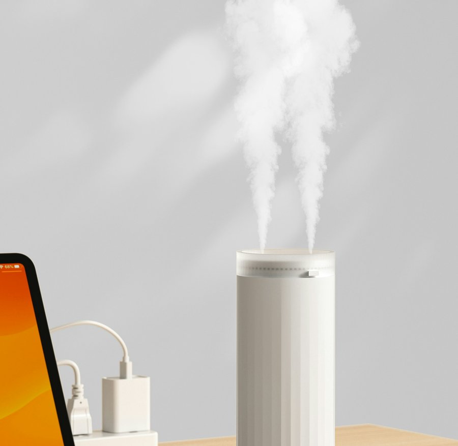 A white cool mist humidifier releasing vapor on a wooden desk, a stock photo that stands in for the black ROSEKM 2L model