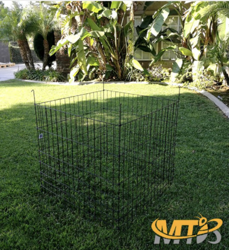 Black square wire mesh compost bin assembled in a backyard corner