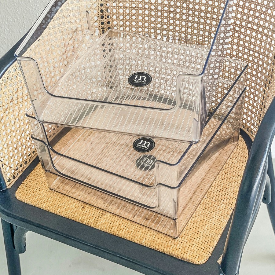 Clear stackable plastic storage bins on a shelf